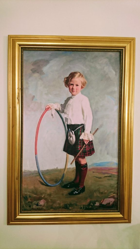 Portrait of a boy in a kilt with hoop and stick